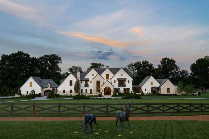 River Song Haven - Close-up of modern glass lantern sconces mounted on stone arches of a custom Castle Homes residence