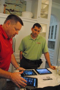 Tom Lundborg, president of A.C.E. Technologies, gives Brett Wright, Castle Homes project manager, an iPad touch screen tutorial.